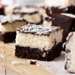 A closeup of one coconut brownie with others blurred in the background