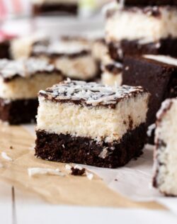 A closeup of one coconut brownie with others blurred in the background