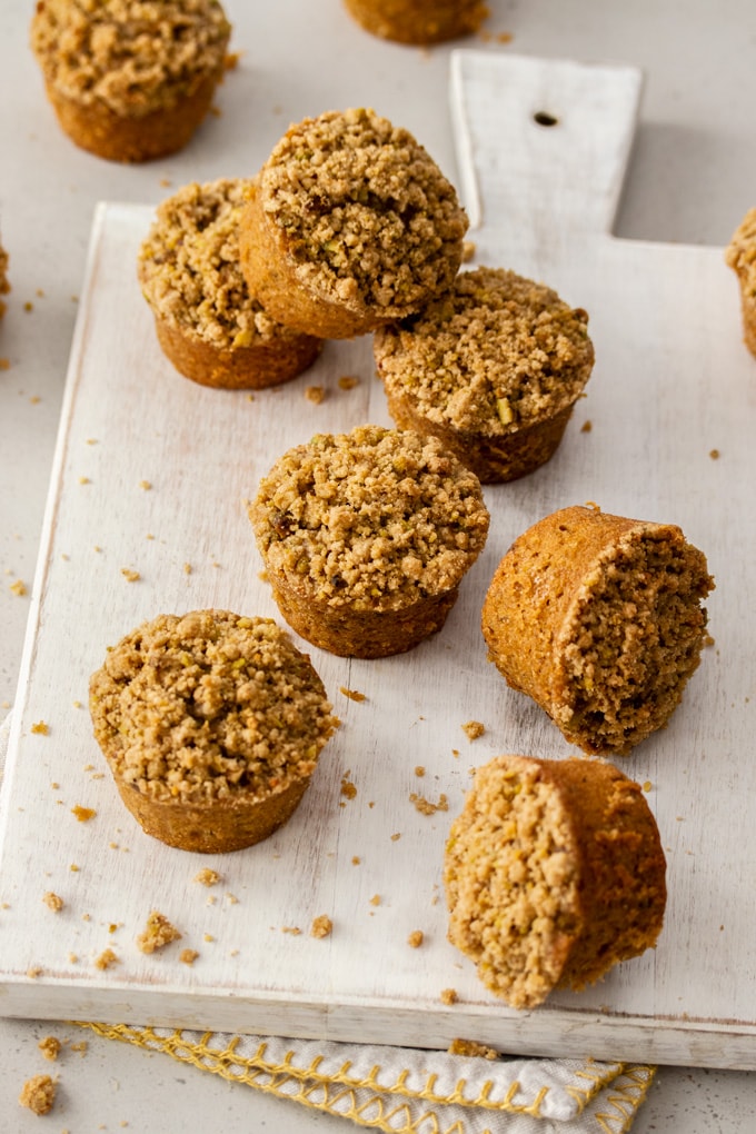 8 Carrot Cake muffins on a white board with crumbs around