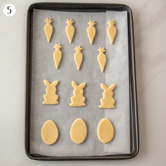 13 sugar cookie dough cutouts sitting on a baking tray