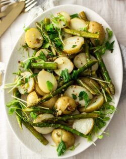 Birdseye view of potato asparagus salad on a white plate