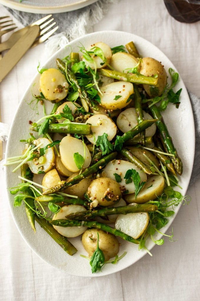 Birdseye view of potato asparagus salad on a white plate