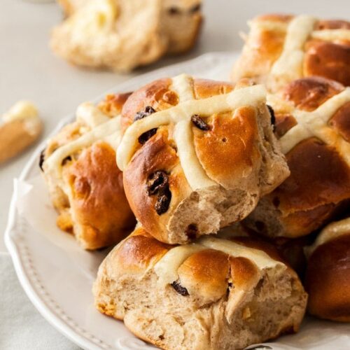 A white plate filled with hot cross buns.