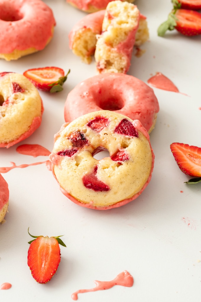 A doughnut turned upside down showing the strawberries underneath
