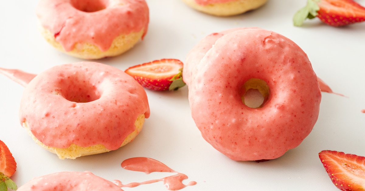 2 baked doughnuts with pink strawberry glaze