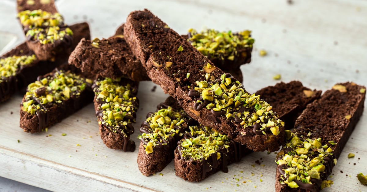 A stack of pistachio chocolate biscotti on a board