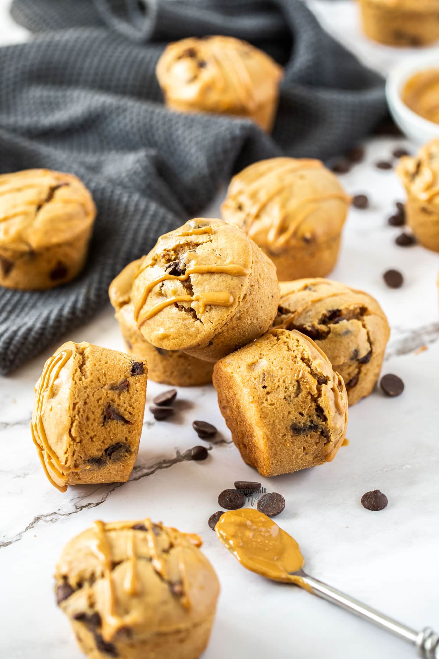 muffins stacked together with chocolate chips and peanut butter strewn around