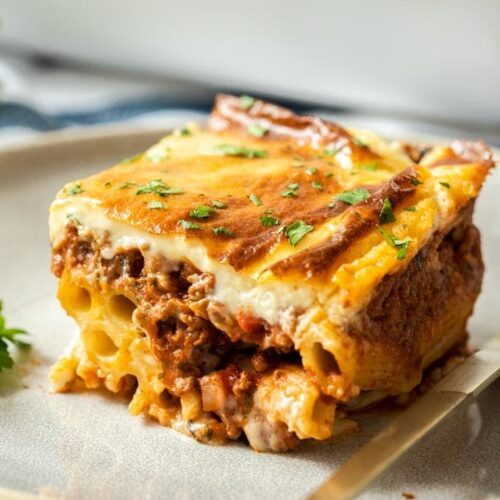 Closeup of a slice of pastitsio on a grey plate
