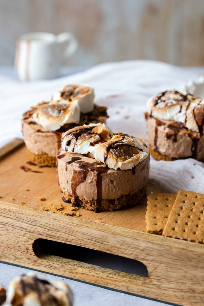 3 Mini S'mores cheesecakes sitting on a wooden tray