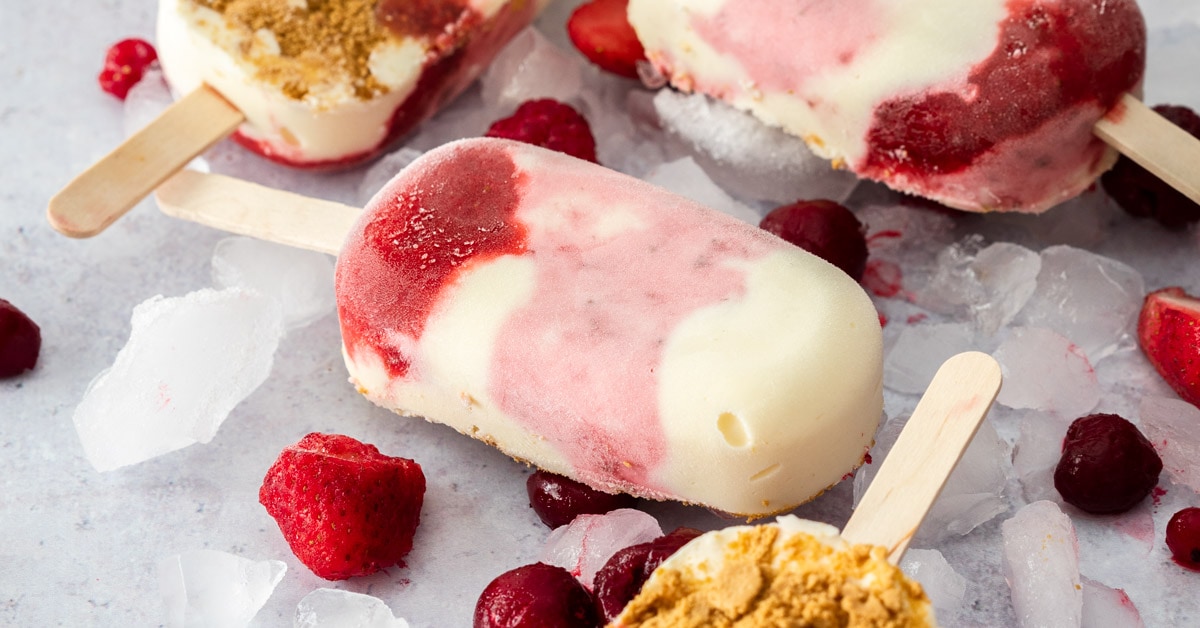 Closeup of a Strawberry Cheesecake Ice cream bar surrounded by ice and berries