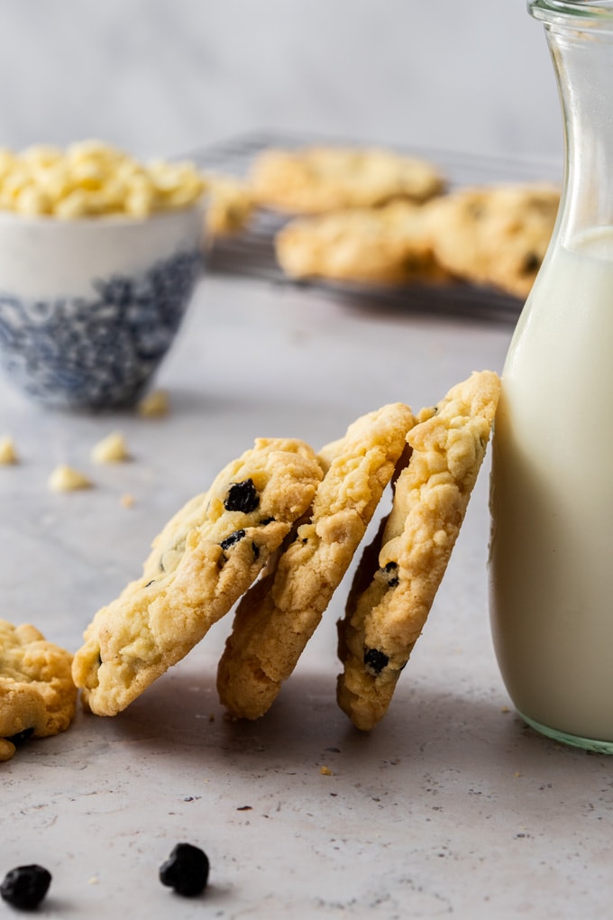 3 cookies stacked up against a bottle of milk