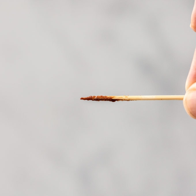 A toothpick with lots of brownie batter sticking to it