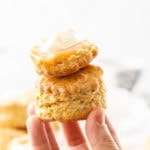 Two scones being held up by a hand