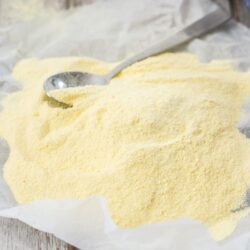A piece of baking paper with yellow custard powder piled on top