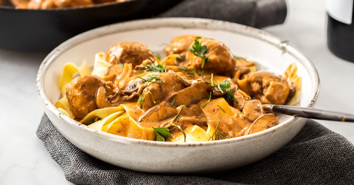 A grey bowl filled with meatball stroganoff