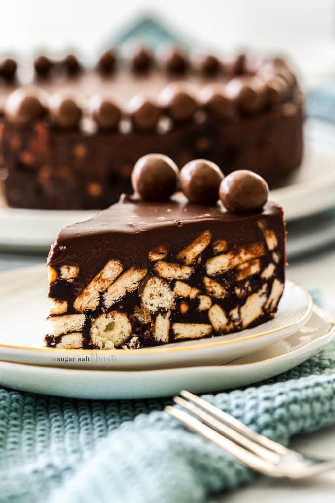 A slice of chocolate fridge cake upright on a dessert plate.