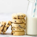 A stack of chocolate chip shortbread leaning up against a bottle of milk