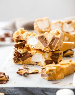 Two pieces of Caramel rocky road stacked on top of one another with other slices around.