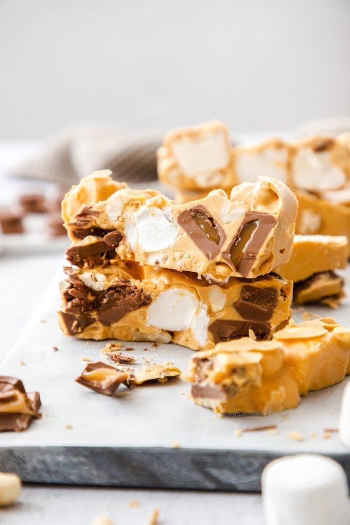 Two pieces of Caramel rocky road stacked on top of one another with other slices around.