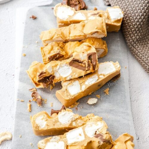 A batch of caramel white chocolate rocky road slices on a marble board