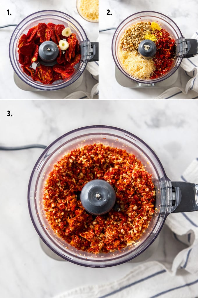 A food processor with ingredients for tomato pesto at various stages of making