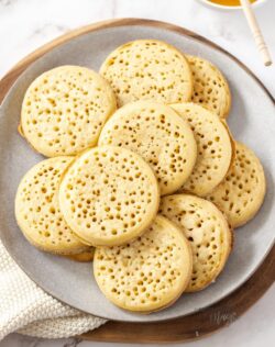A pile of crumpets on a grey plate