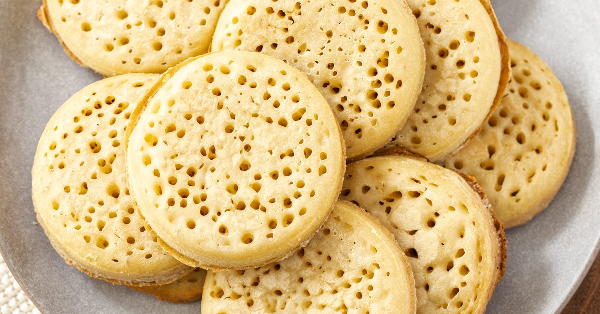 A pile of crumpets on a grey plate