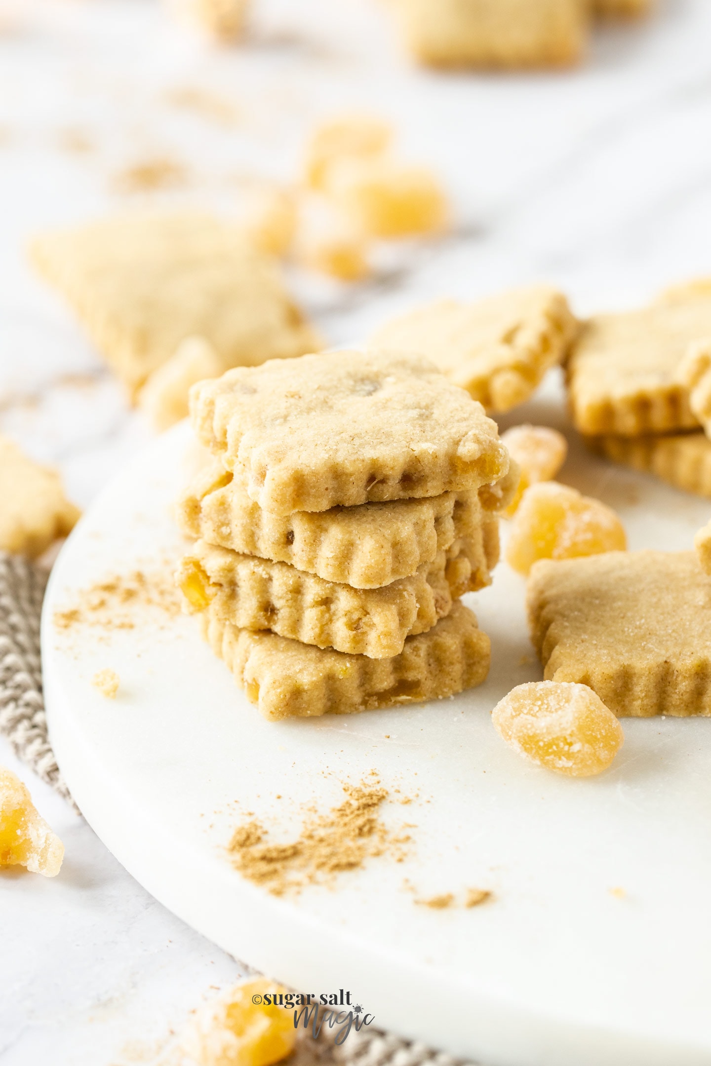 A batch of ginger shortbread surrounded by candied ginger