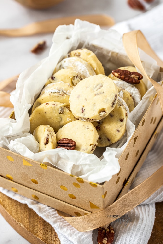 A batch of pecan sandies in a brown and gold gift box