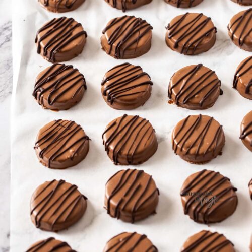 18 chocolate coated cookies on a sheet of baking paper