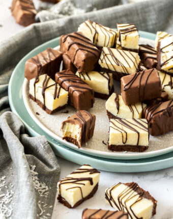 A plate full of pieces of fudge, some coated in chocolate