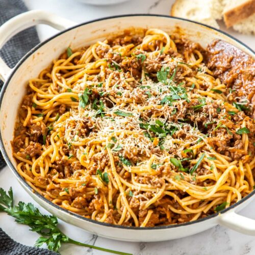 A white casserole dish filled with spaghetti bolognese