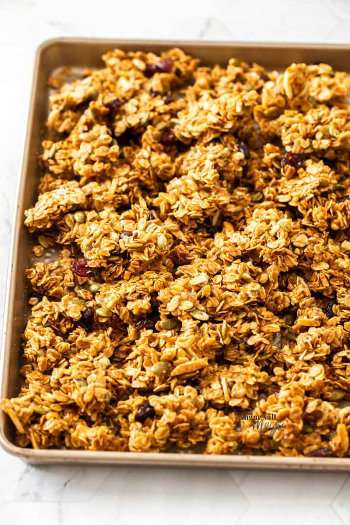 A gold baking tray filled with granola clusters