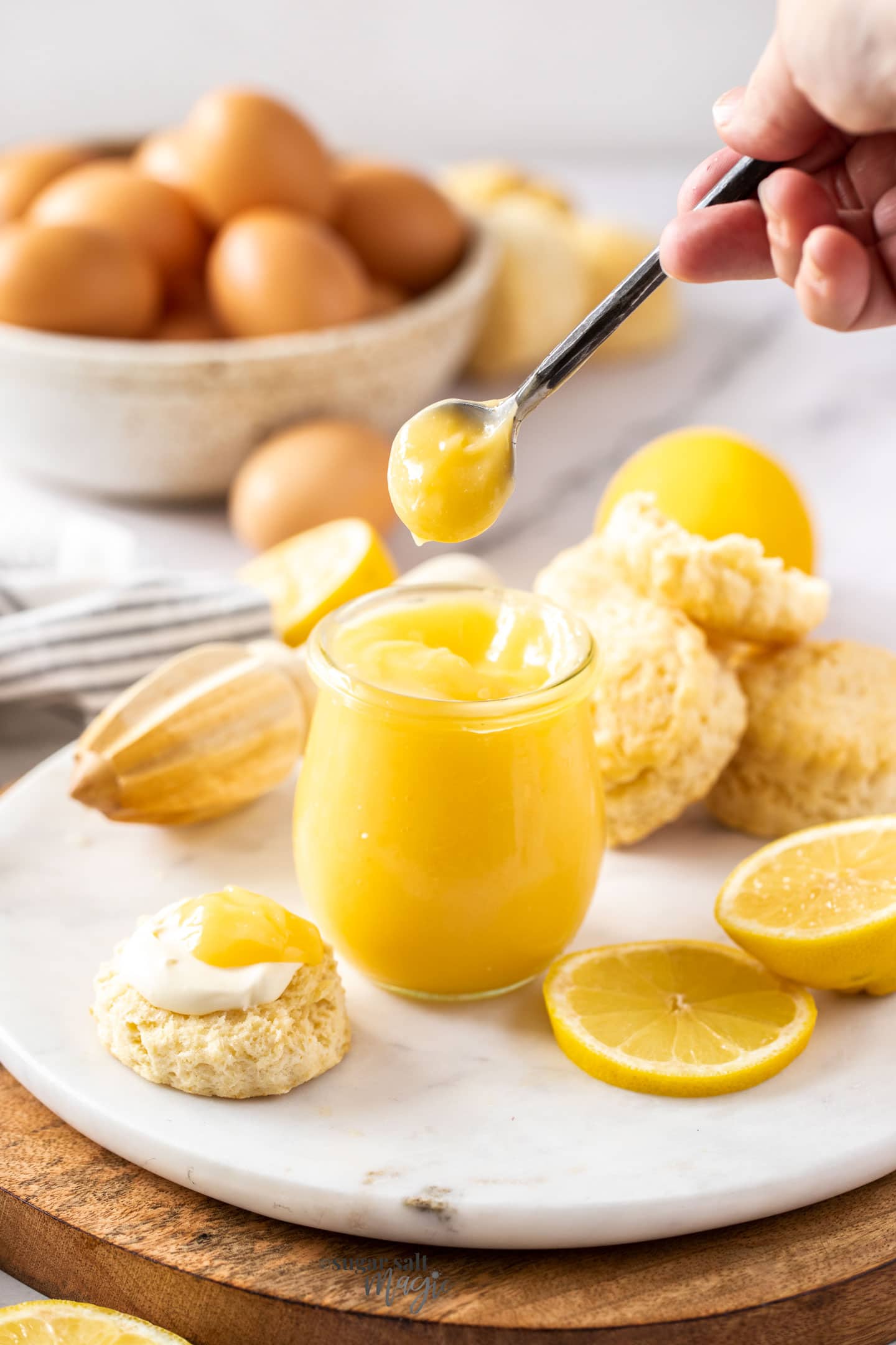 A spoon coming out of a jar of lemon curd