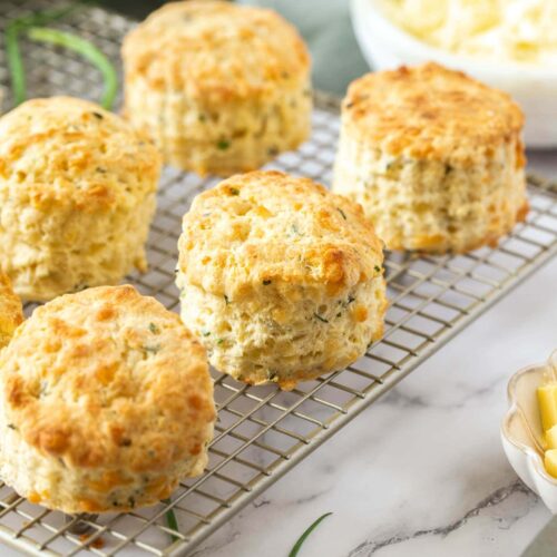 Closeup of 5 cheese scones on a wire cooling rack.