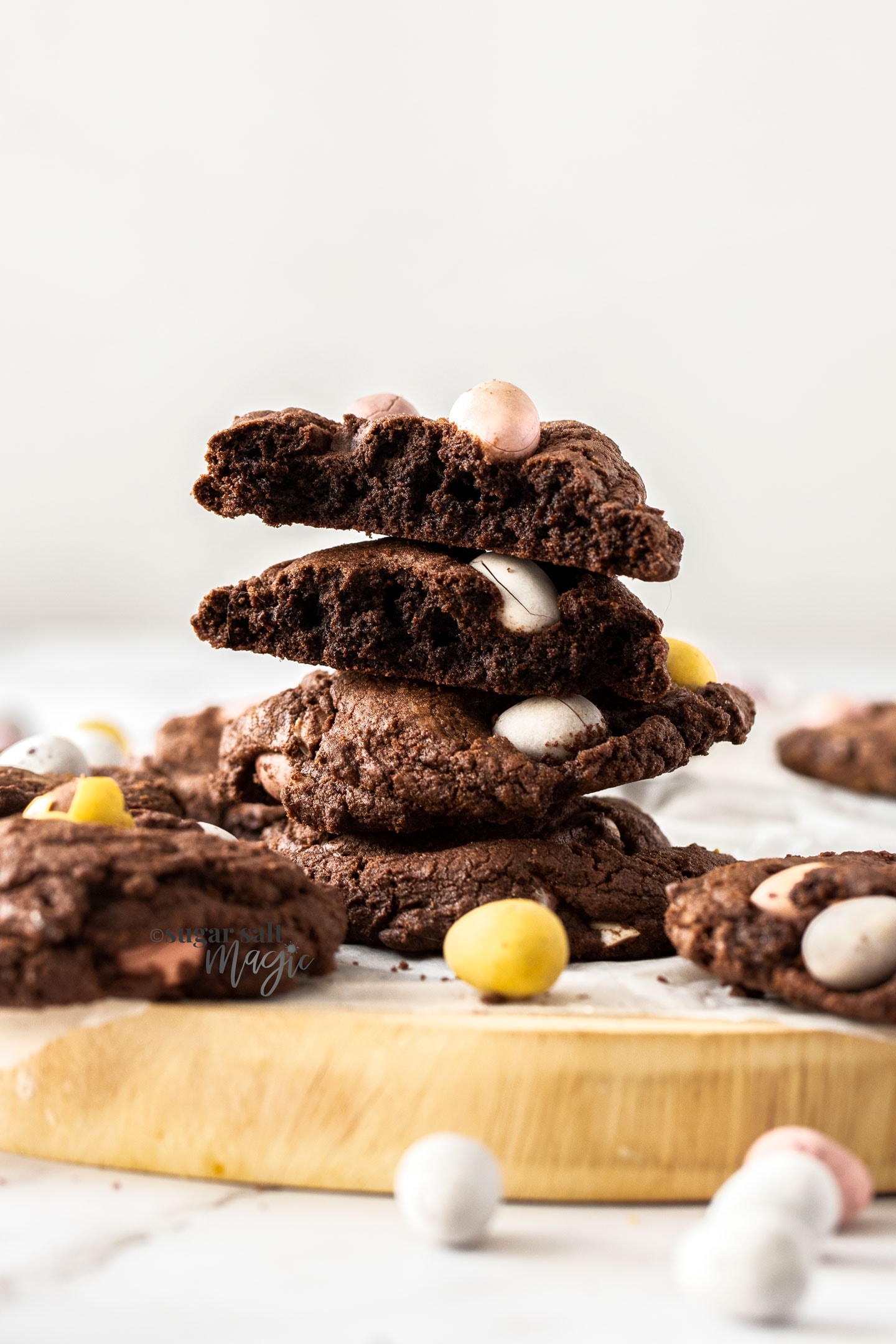A stack of chocolate cookies with Easter eggs around them.