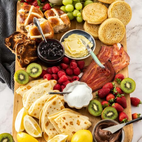 A wooden board filled with breakfast foods.