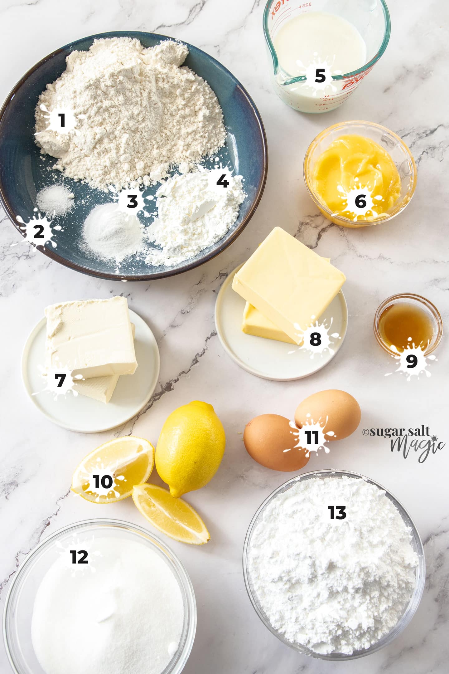Ingredients for lemon cupcakes on a marble surface.