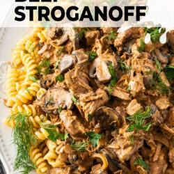 A white dish filled with pasta and beef stroganoff.