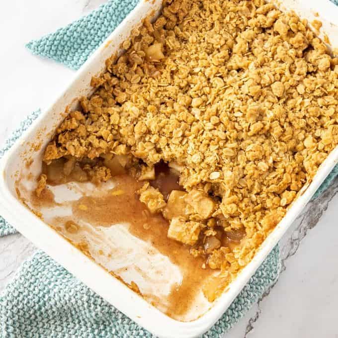 Top down view of apple crumble in a white rectangular dish.