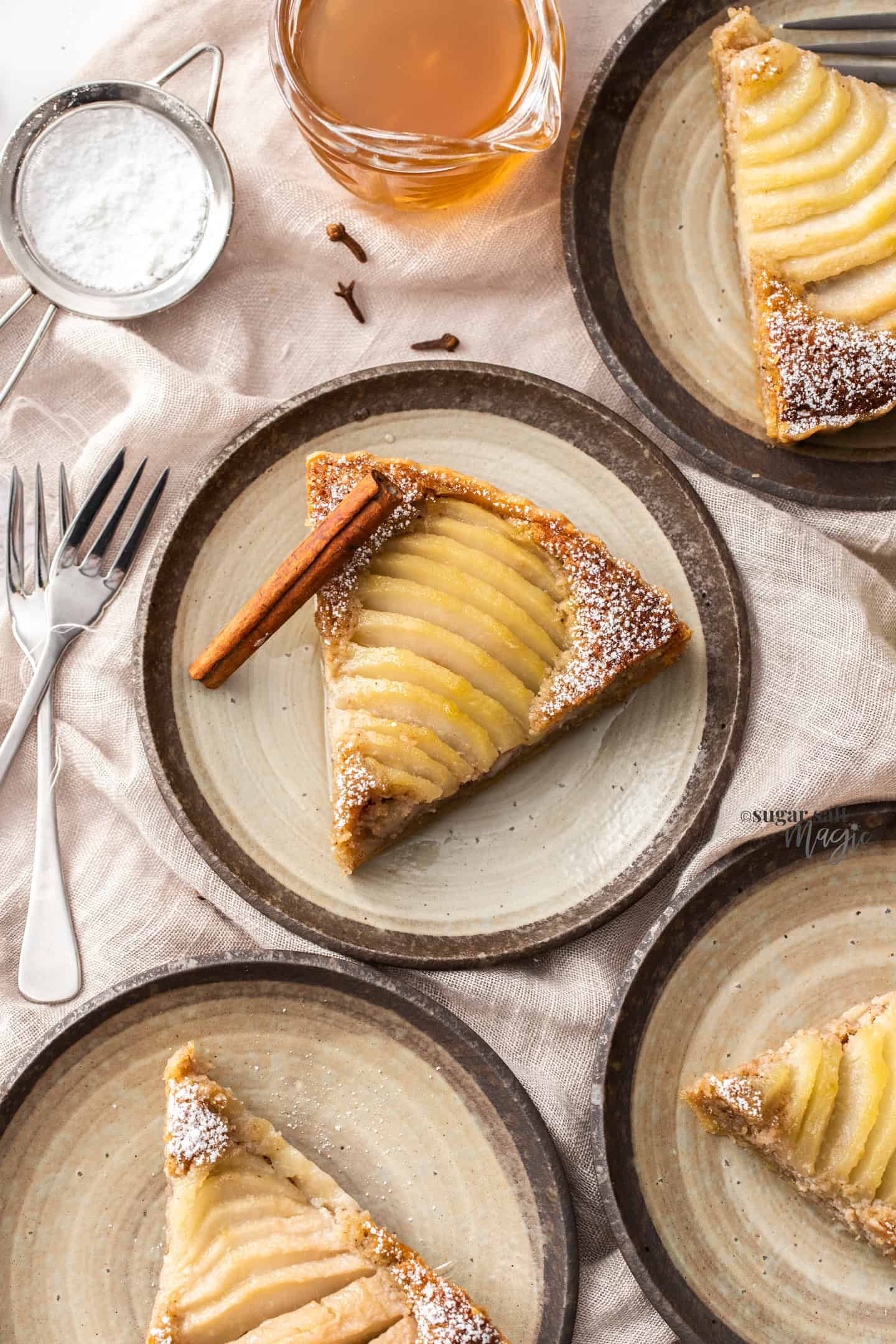 4 small cake plates, each with a slice of pear tart.