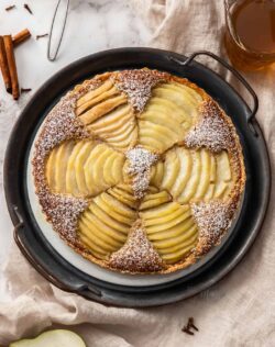 Top down view of a tart with 6 sliced pears in it.