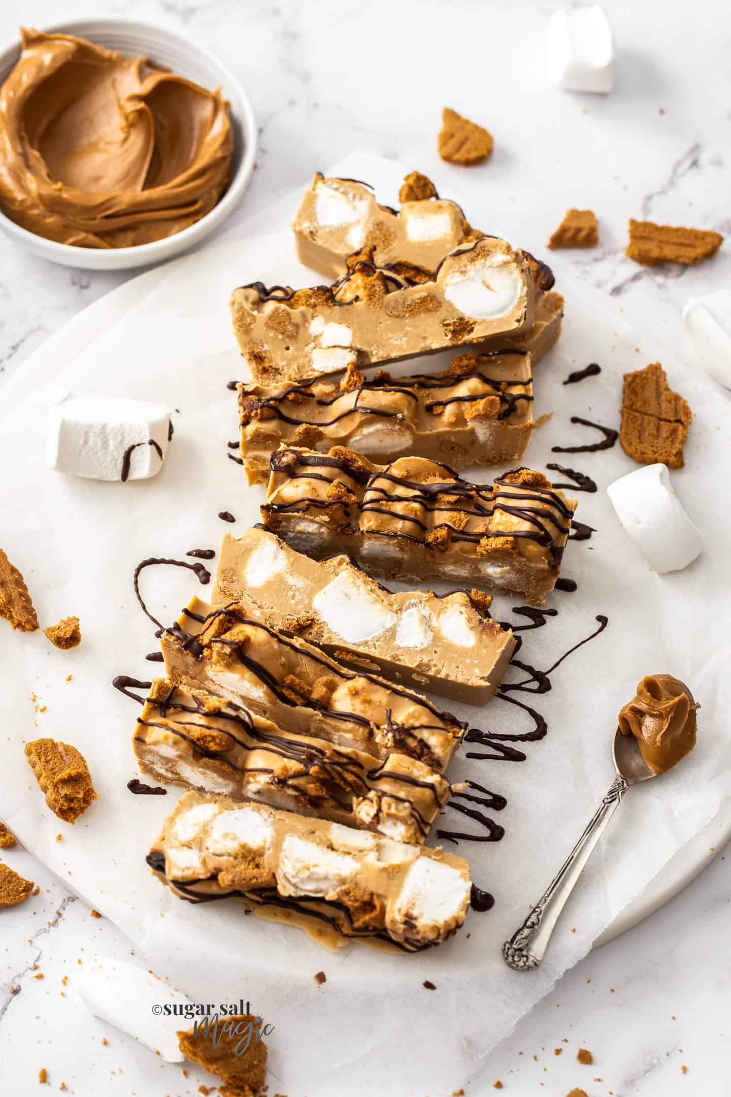 Many slices of biscoff rocky road on a sheet of baking paper.