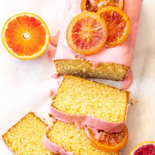 Top down view of an orange loaf cake with slices cut from it.
