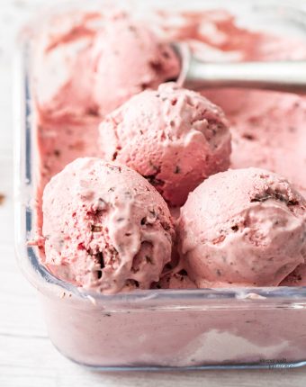 Closeup of 3 scoops of ice cream in a glass ice cream tub.