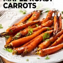 A batch of roasted baby carrots on a white platter.
