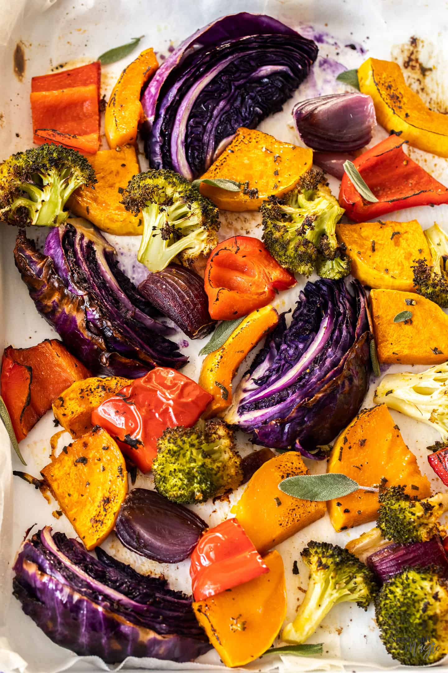 A variety of roasted vegetables on a sheet pan.