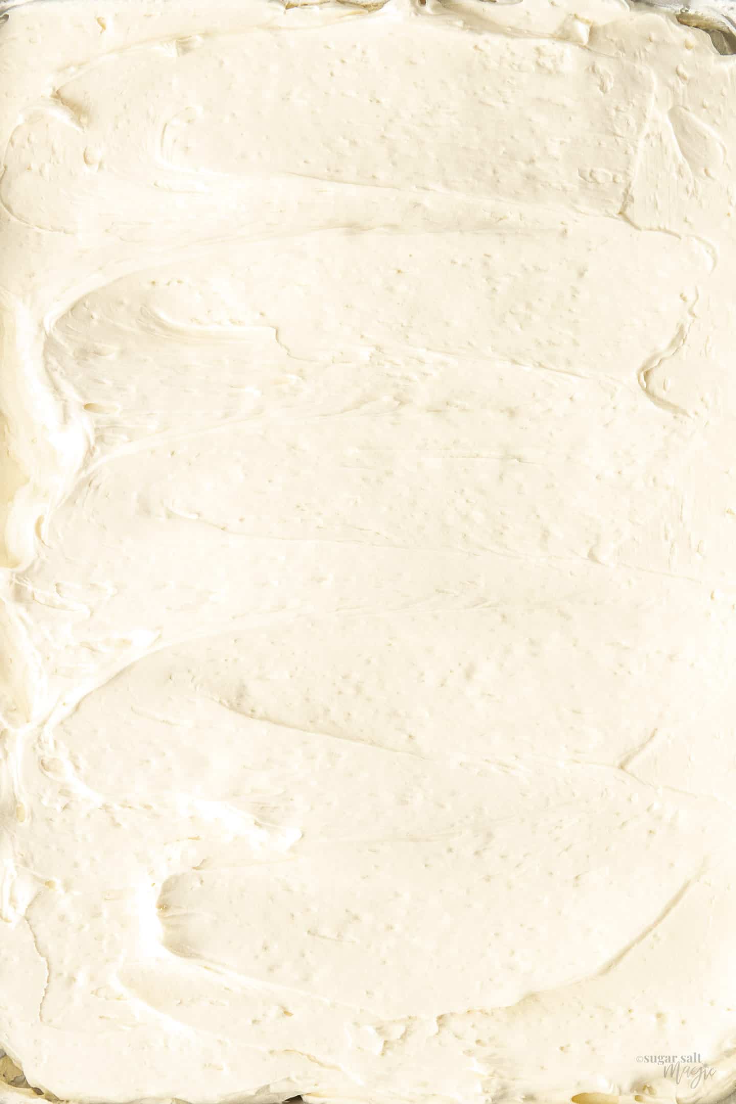 Swirls of Swiss meringue buttercream spread out on tray.