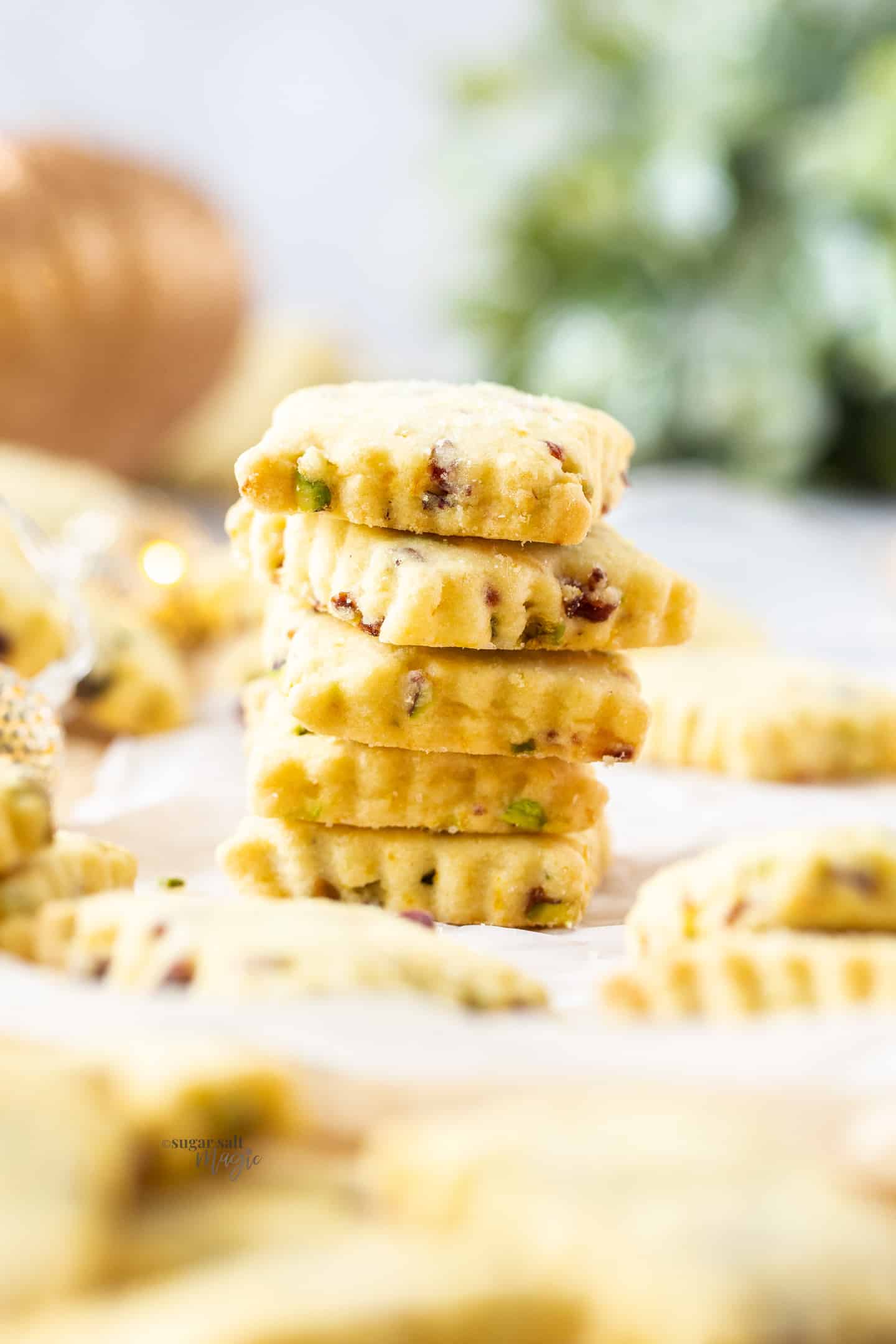 A stack of 5 square cranberry pistachio shortbread cookies.