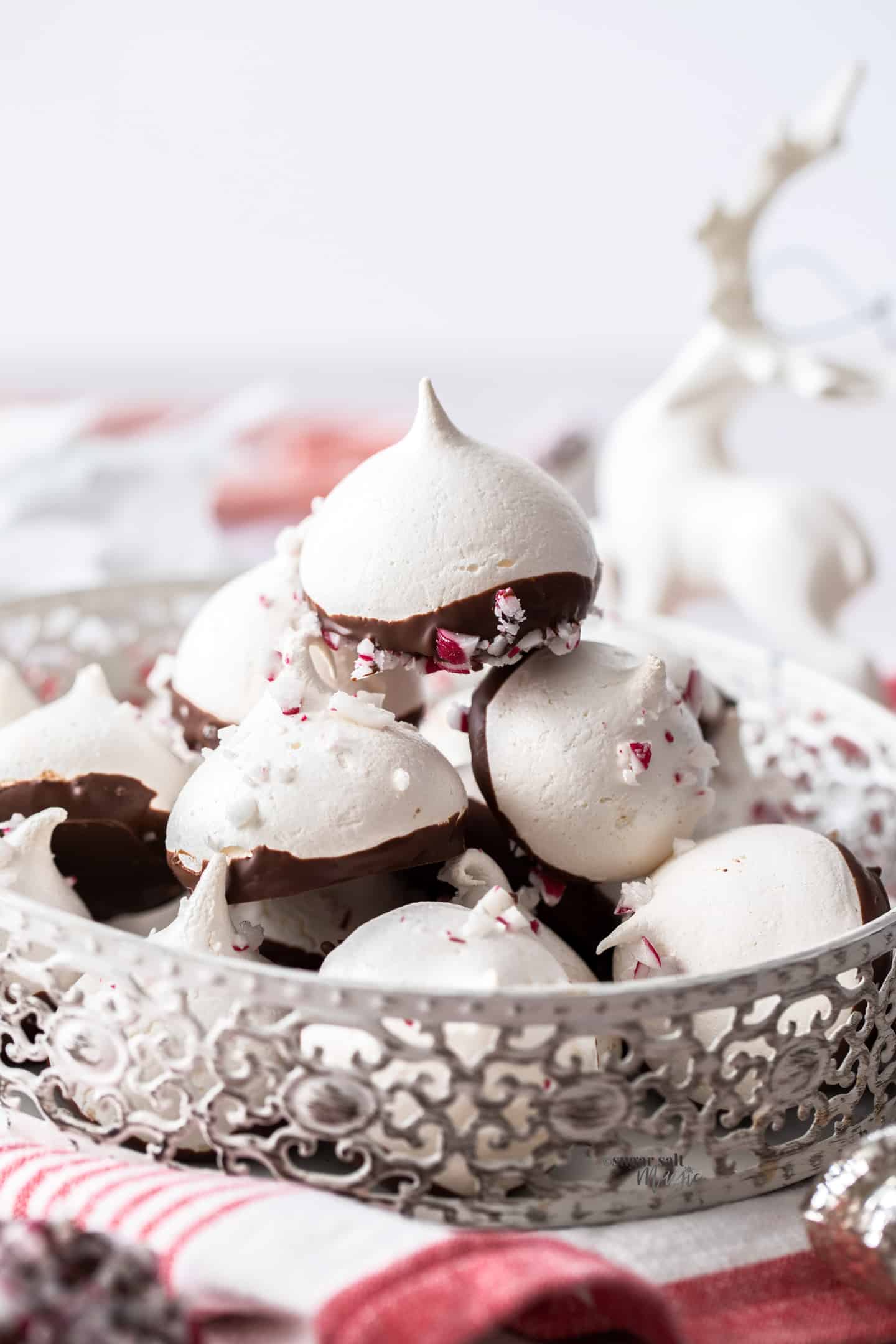 A small white tin filled with a batch of peppermint meringues.
